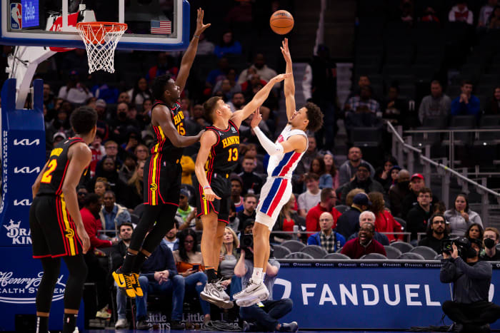 Mar 7, 2022; Detroit, Michigan, USA; Detroit Pistons guard Cade Cunningham (2) takes a shot over Atlanta Hawks guard Bogdan Bogdanovic (13) and center Clint Capela (15) during the first quarter at Little Caesars Arena.